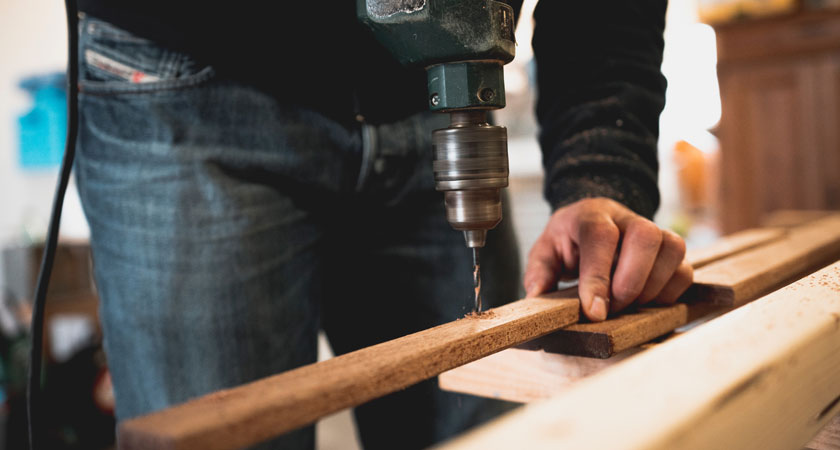 A person using a drill to make something.