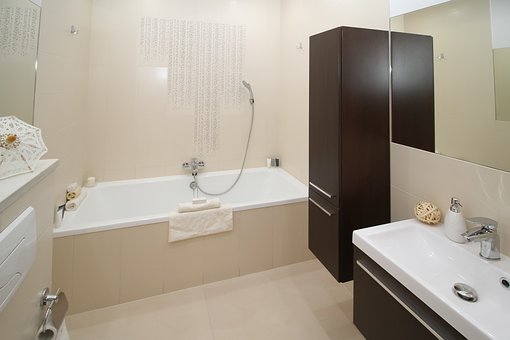 A bathroom with a tub, sink and mirror.