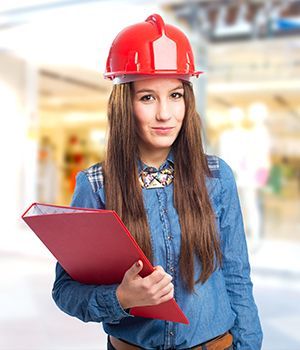 A woman wearing a hard hat holding a red folder.