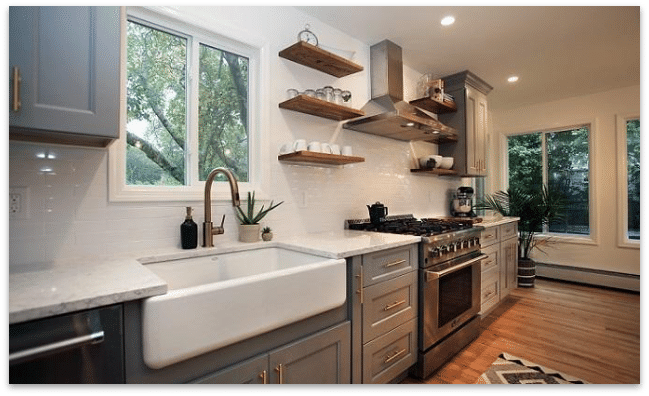 A kitchen with an oven, sink and window.