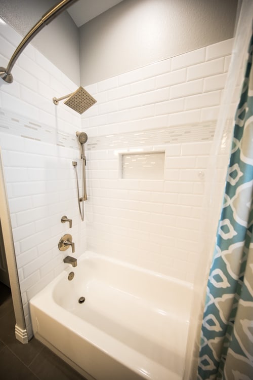 A white bath tub sitting next to a shower.