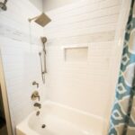 A white bath tub sitting next to a shower.