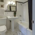 A bathroom with white tile and black accents.