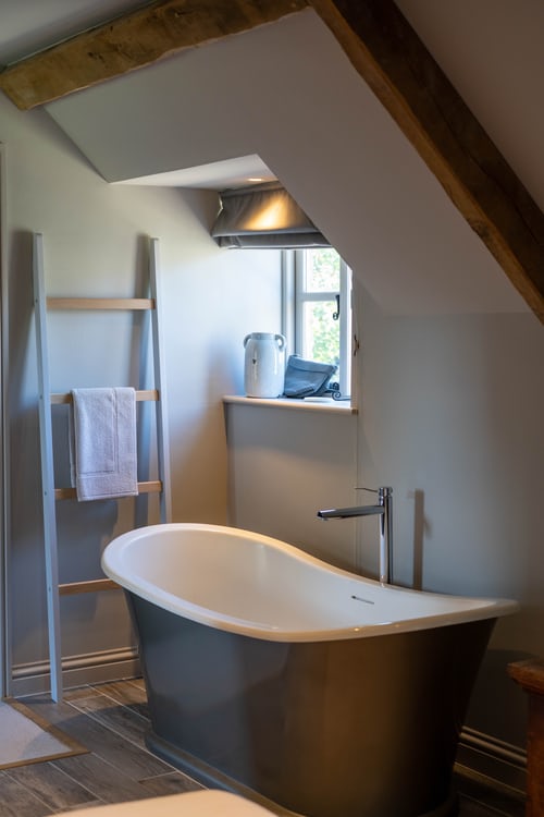 A bathroom with a tub and ladder in it