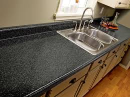 A kitchen with black granite counter top and silver sink.