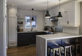 A kitchen with white cabinets and black counter tops.