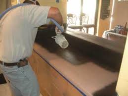 A man is painting the counter top.