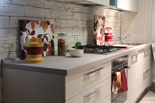 A kitchen with white cabinets and a stove top oven.